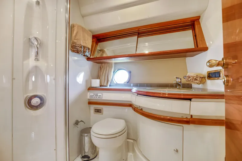  Yacht Photos Pics Luxurious bathroom in 2005 Azimut 55E yacht with elegant wood accents and modern fixtures.