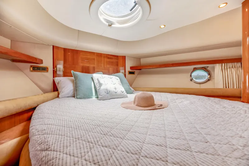  Yacht Photos Pics Luxurious bedroom interior of 2005 Azimut 55E yacht with cozy bedding and porthole view.
