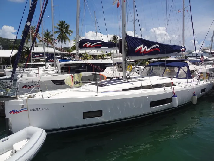 Tabula Rasa Yacht Photos Pics 2020 Beneteau Oceanis 46.1 sailboat docked in a marina with palm trees.