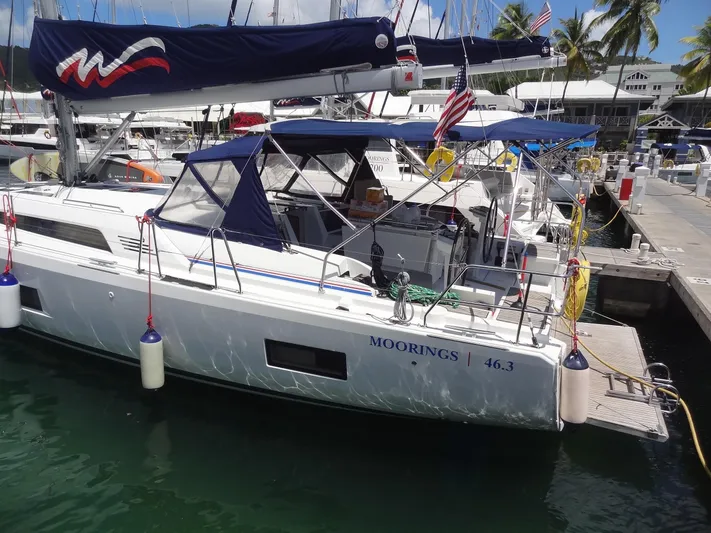 Tabula Rasa Yacht Photos Pics 2020 Beneteau Oceanis 46.1 sailboat docked at marina with blue canopy and flags.