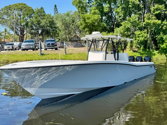  Yacht Photos Pics 2009 Invincible 36 Open Fisherman boat on calm water, surrounded by trees and parked cars.