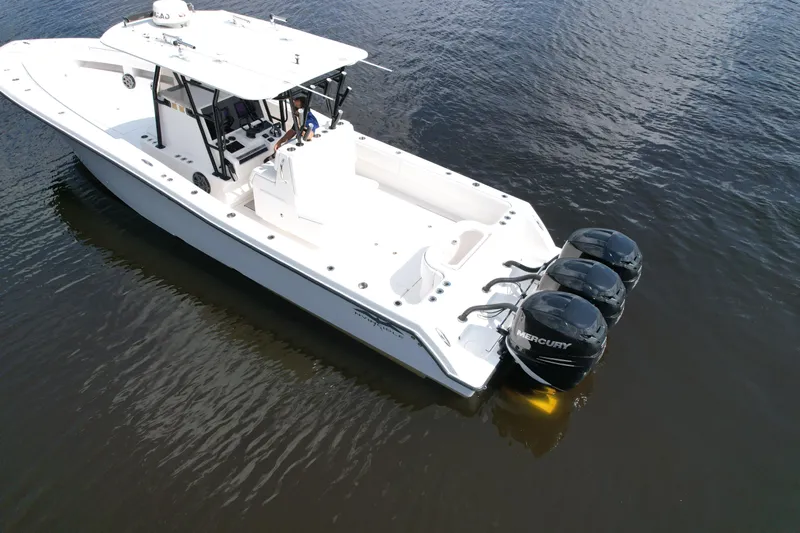  Yacht Photos Pics 2009 Invincible 36 Open Fisherman boat with triple Mercury engines on calm water.