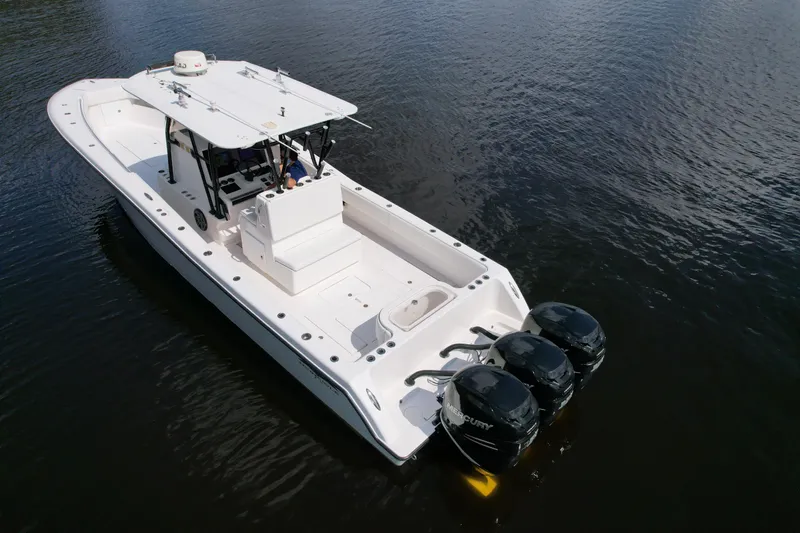  Yacht Photos Pics 2009 Invincible 36 Open Fisherman boat with triple outboard engines on calm water.