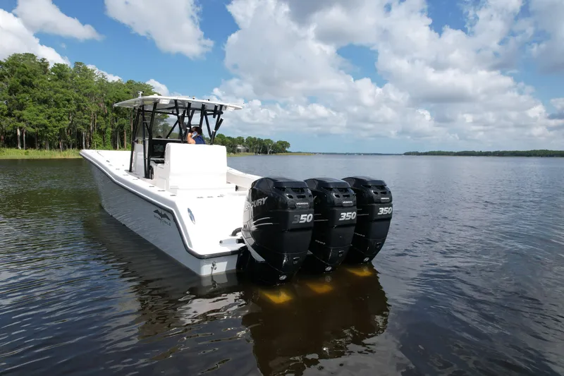  Yacht Photos Pics 2009 Invincible 36 Open Fisherman boat with triple 350 engines on a calm lake.