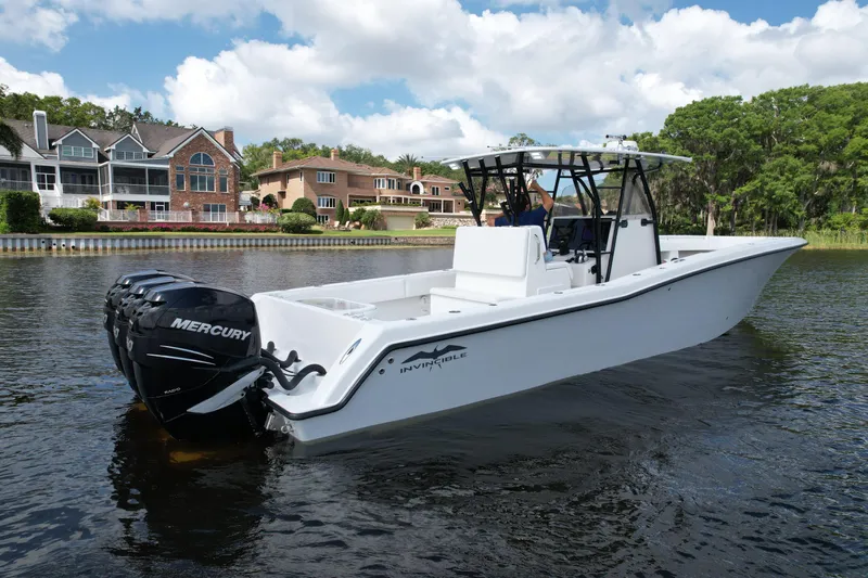  Yacht Photos Pics 2009 Invincible 36 Open Fisherman boat on water, with Mercury engines, near waterfront homes.