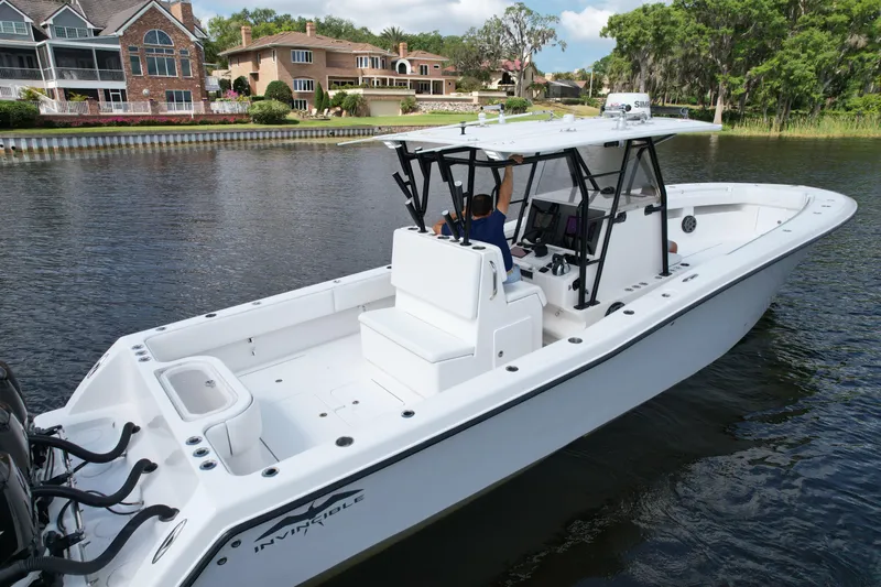  Yacht Photos Pics 2009 Invincible 36 Open Fisherman boat on a calm river near luxury homes.