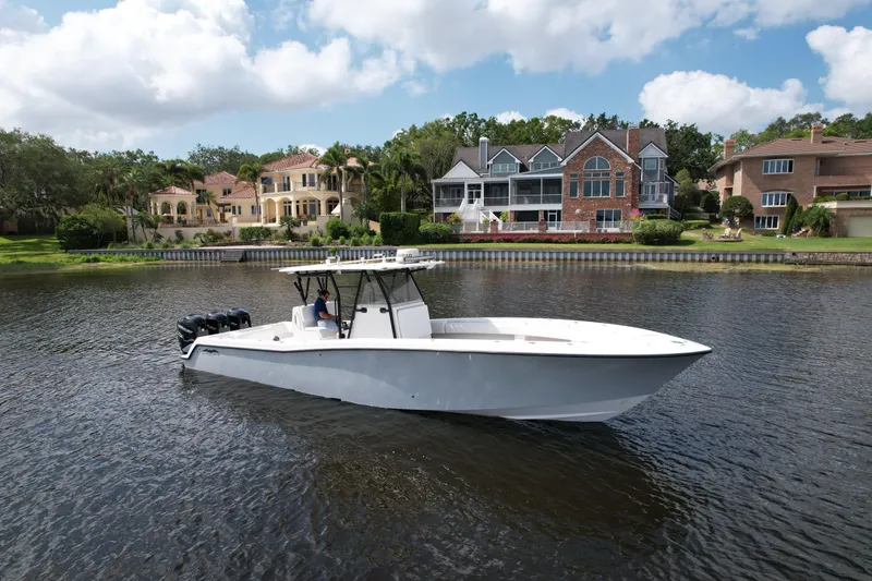 Yacht Photos Pics 2009 Invincible 36 Open Fisherman boat on a scenic waterfront with luxury homes.