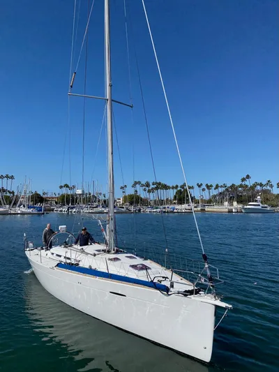 Saga Yacht Photos Pics 2012 Beneteau First 40 sailboat cruising in a sunny marina with palm trees.