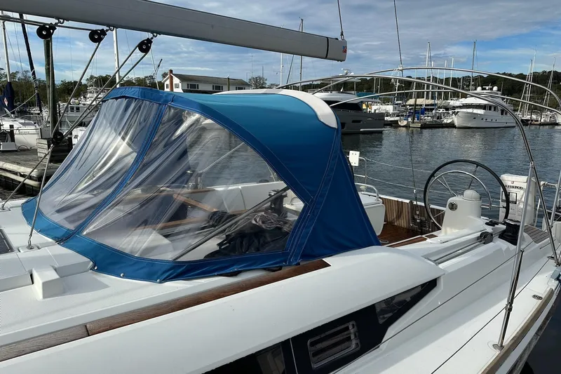  Yacht Photos Pics 2018 Jeanneau Sun Odyssey 479 sailboat docked at marina with blue canopy.