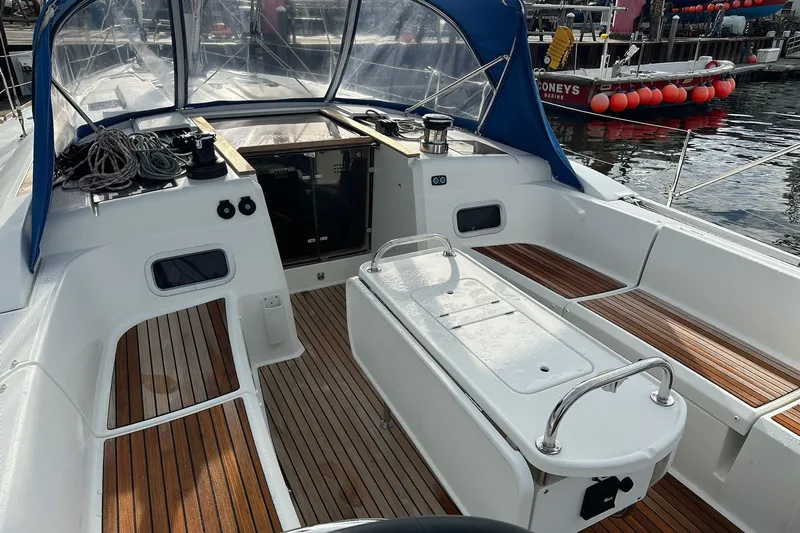  Yacht Photos Pics 2018 Jeanneau Sun Odyssey 479 sailboat cockpit with teak flooring and blue canopy.