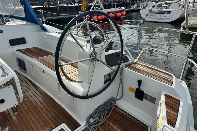  Yacht Photos Pics 2018 Jeanneau Sun Odyssey 479 sailboat cockpit with wooden deck and steering wheel.