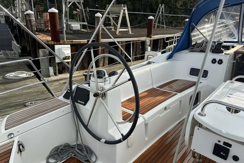  Yacht Photos Pics 2018 Jeanneau Sun Odyssey 479 sailboat cockpit with wooden seating and steering wheel.