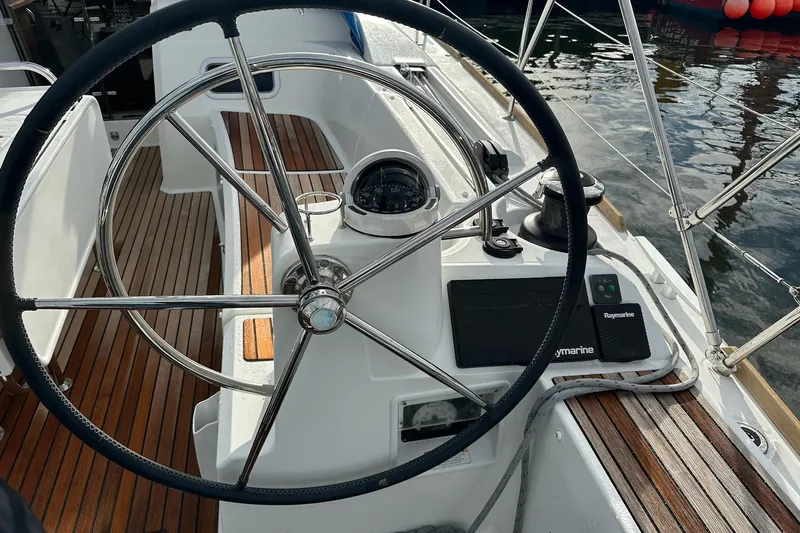  Yacht Photos Pics Steering wheel of 2018 Jeanneau Sun Odyssey 479 sailboat with wooden deck and navigation equipment.