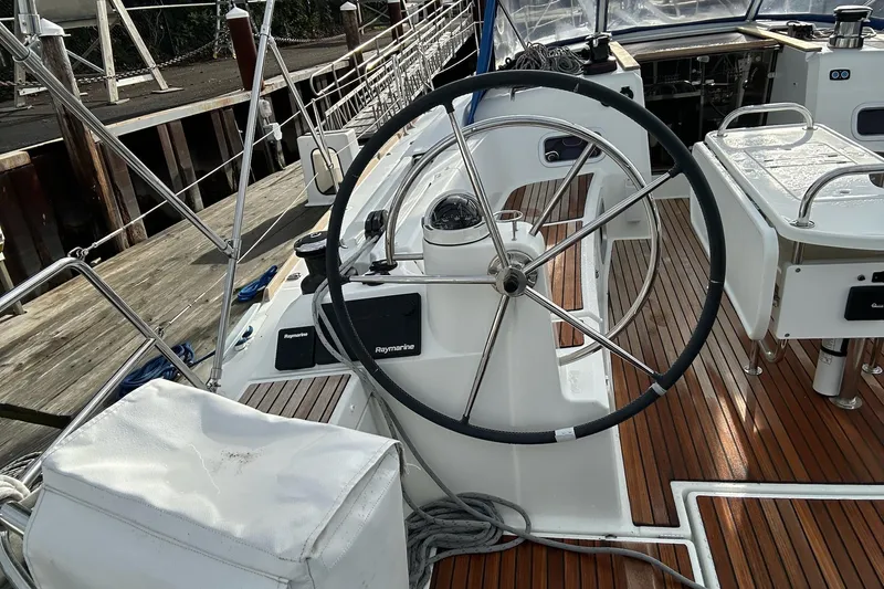  Yacht Photos Pics Steering wheel of 2018 Jeanneau Sun Odyssey 479 sailboat with teak deck and Raymarine equipment.