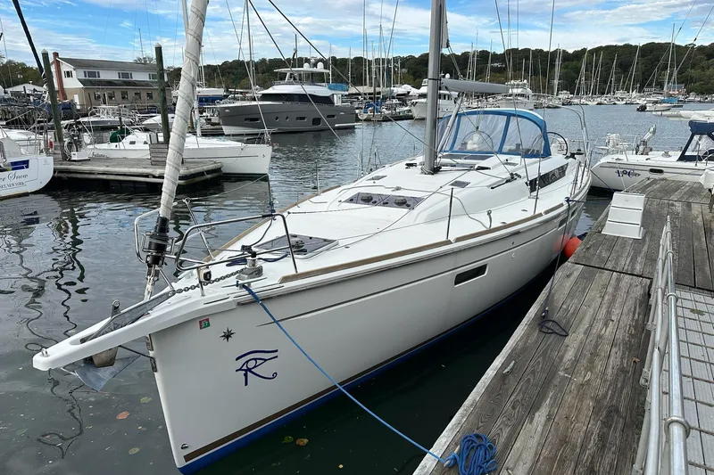  Yacht Photos Pics 2018 Jeanneau Sun Odyssey 479 sailboat docked in a marina, surrounded by other boats.