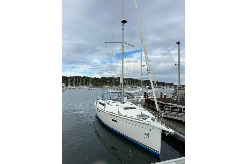  Yacht Photos Pics 2018 Jeanneau Sun Odyssey 479 sailboat docked in a marina under cloudy skies.