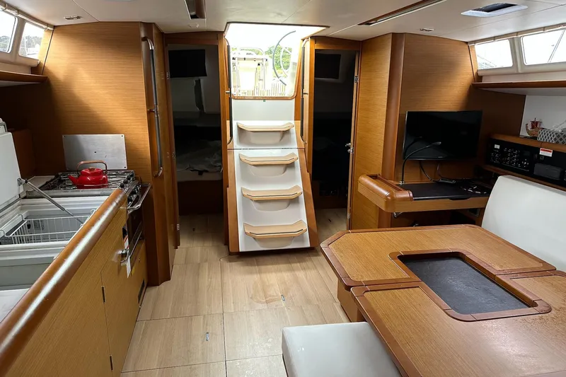  Yacht Photos Pics 2018 Jeanneau Sun Odyssey 479 interior with kitchen, dining area, and navigation station.