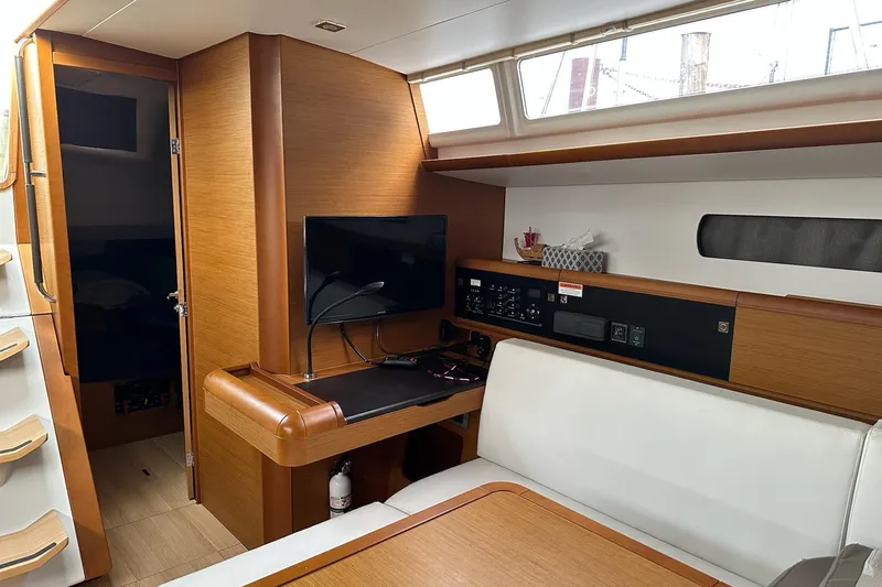  Yacht Photos Pics Interior of 2018 Jeanneau Sun Odyssey 479 yacht with modern wood finish and seating area.