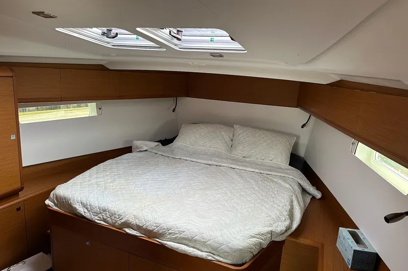  Yacht Photos Pics Cozy cabin interior of 2018 Jeanneau Sun Odyssey 479 with double bed and wooden finish.