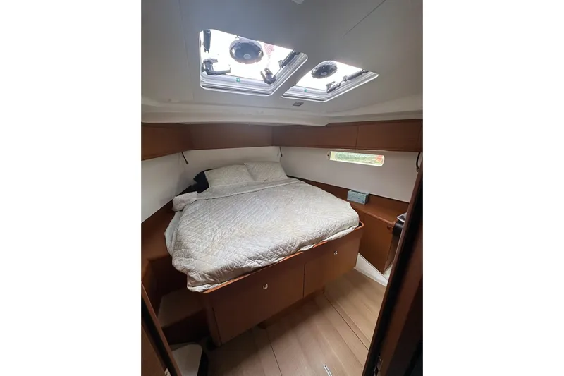  Yacht Photos Pics Cozy cabin interior of 2018 Jeanneau Sun Odyssey 479 sailboat with bed and skylight.