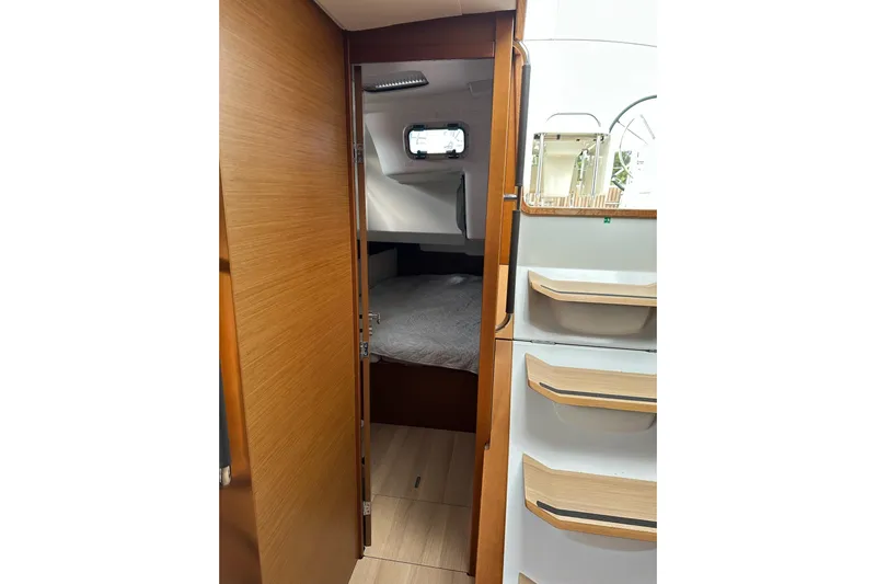  Yacht Photos Pics Interior cabin of 2018 Jeanneau Sun Odyssey 479 sailboat, featuring wood finish and cozy sleeping area.