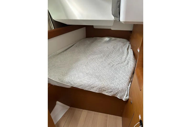  Yacht Photos Pics Cozy cabin bed in 2018 Jeanneau Sun Odyssey 479 sailboat, featuring wooden interior.