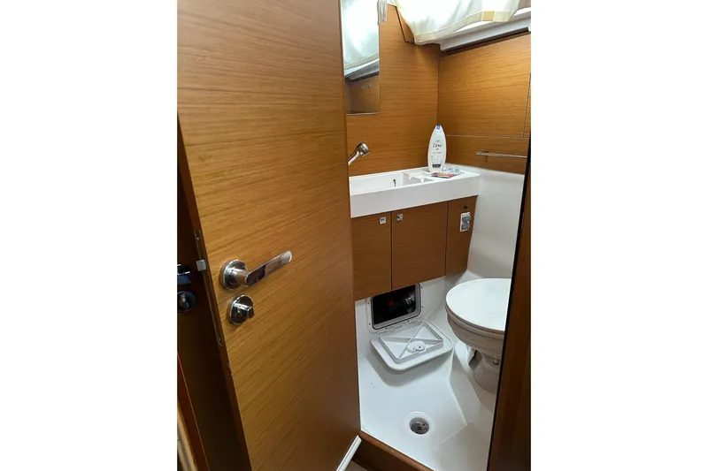  Yacht Photos Pics 2018 Jeanneau Sun Odyssey 479 bathroom with wooden cabinetry and modern fixtures.
