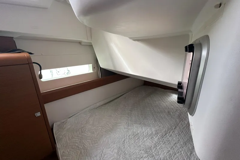  Yacht Photos Pics Cozy cabin interior of 2018 Jeanneau Sun Odyssey 479 sailboat with bed and window.