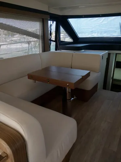  Yacht Photos Pics Modern interior of 2020 Absolute 50 Fly yacht with beige seating and wooden table.