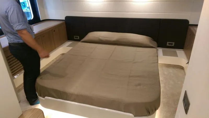  Yacht Photos Pics Luxurious bedroom interior of 2020 Absolute 50 Fly yacht with a neatly made bed.