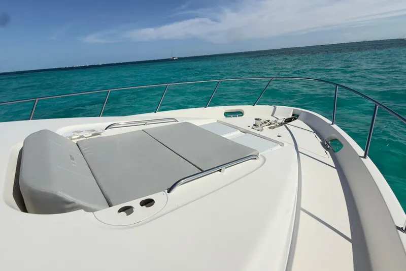 Rubicon Yacht Photos Pics 2008 Meridian 580 Pilothouse yacht deck with sunbed, overlooking turquoise ocean waters.