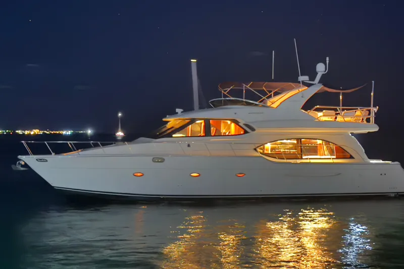 Rubicon Yacht Photos Pics 2008 Meridian 580 Pilothouse yacht illuminated at night on calm water.