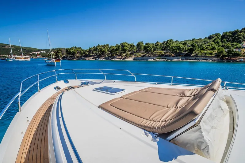 Gitana II Yacht Photos Pics Luxurious 2009 Princess V78 yacht deck with sunbed, overlooking serene blue waters and lush coastline.
