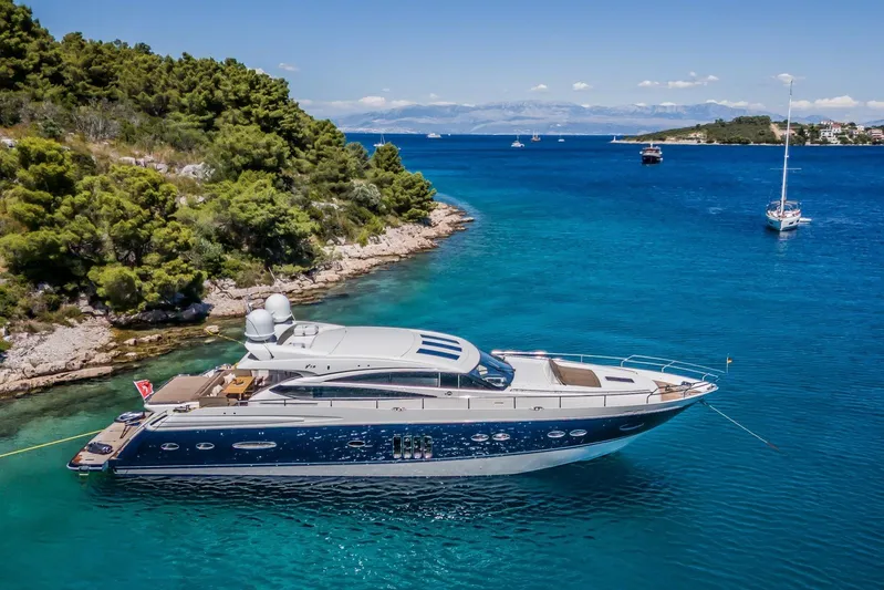 Gitana II Yacht Photos Pics Luxurious 2009 Princess V78 yacht anchored in scenic turquoise bay with lush greenery.