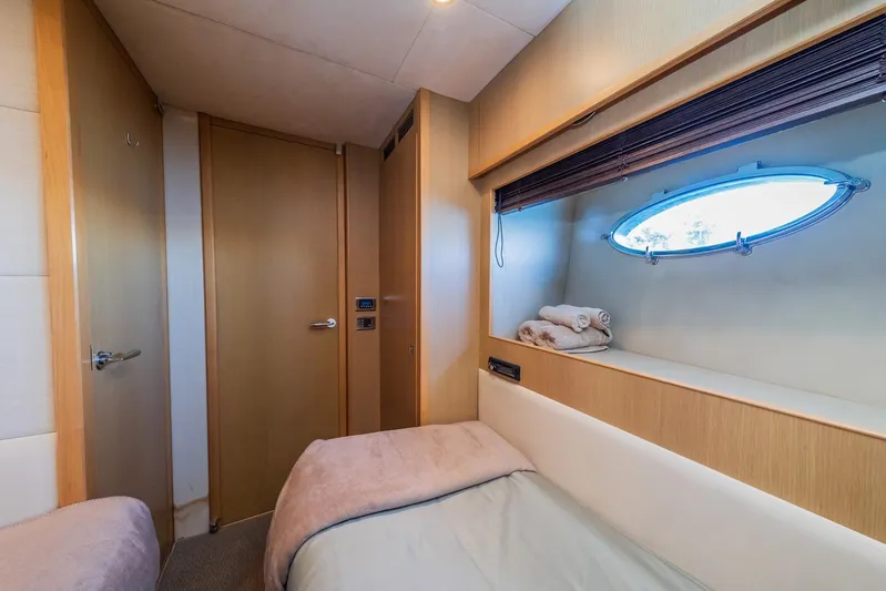 Gitana II Yacht Photos Pics Cozy cabin interior of 2009 Princess V78 yacht with porthole and wooden accents.