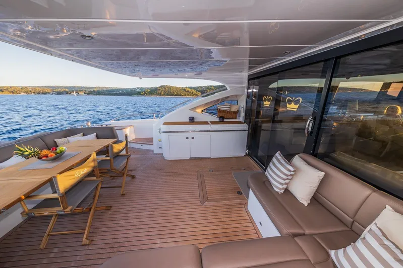 Gitana II Yacht Photos Pics Luxurious 2009 Princess V78 yacht deck with elegant seating and dining area, overlooking serene waters.