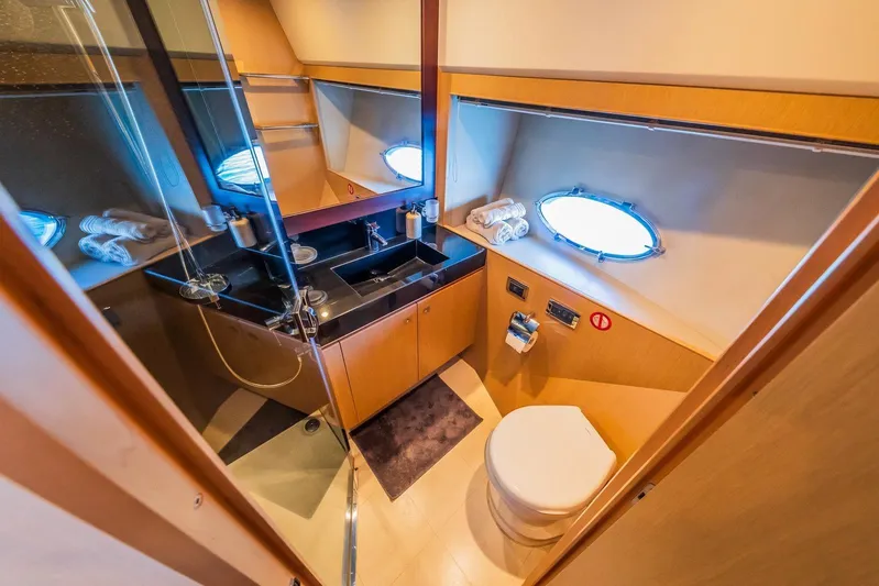 Gitana II Yacht Photos Pics Luxurious bathroom on 2009 Princess V78 yacht with modern fixtures and porthole window.
