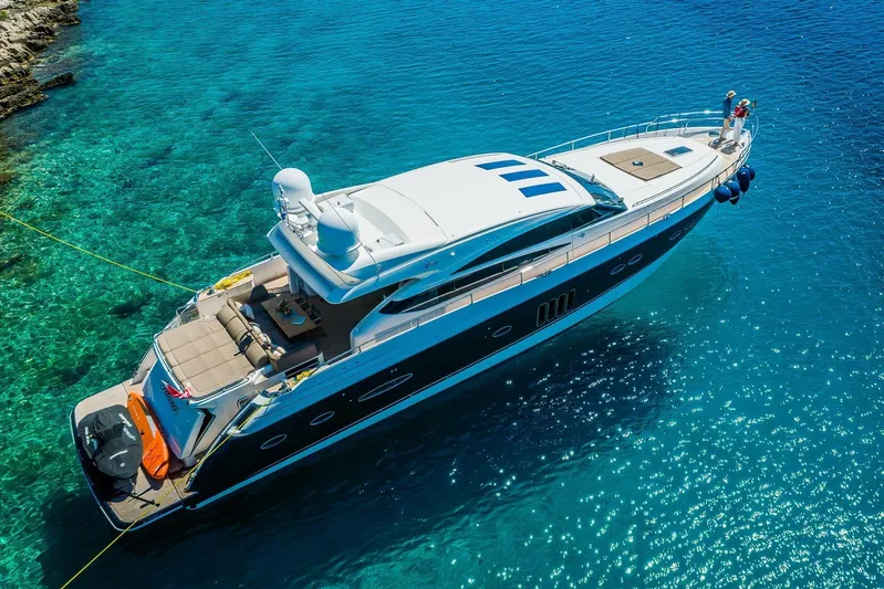 Gitana II Yacht Photos Pics Luxurious 2009 Princess V78 yacht anchored in clear turquoise waters.