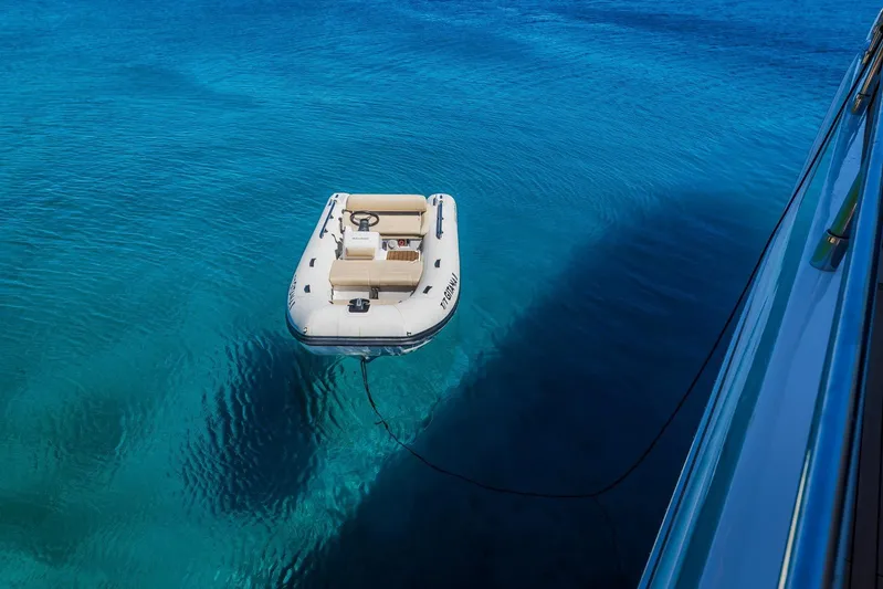 Gitana II Yacht Photos Pics Inflatable boat tethered to a 2009 Princess V78 yacht on clear blue water.