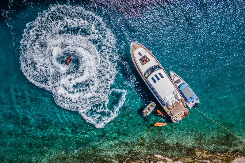 Gitana II Yacht Photos Pics Aerial view of 2009 Princess V78 yacht with jet ski in turquoise water.