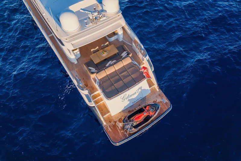 Gitana II Yacht Photos Pics Aerial view of 2009 Princess V78 yacht with deck seating and jet ski on blue ocean.