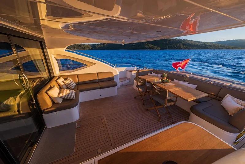 Gitana II Yacht Photos Pics Luxurious 2009 Princess V78 yacht deck with elegant seating and dining area, overlooking serene waters.