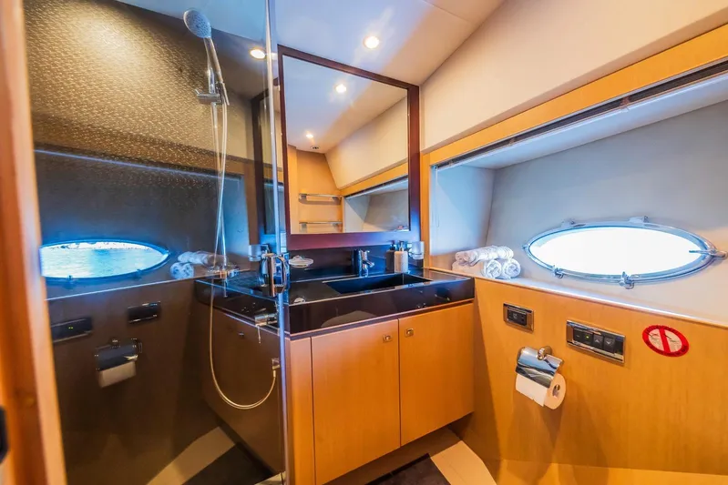 Gitana II Yacht Photos Pics Luxurious bathroom interior of 2009 Princess V78 yacht with modern fixtures and porthole window.
