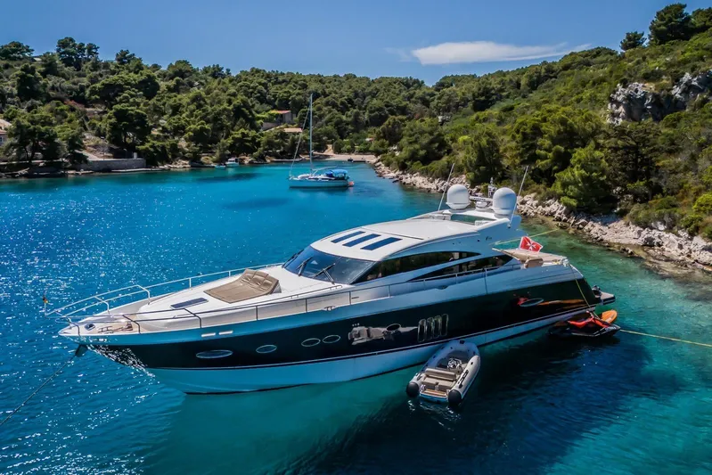 Gitana II Yacht Photos Pics Luxurious 2009 Princess V78 yacht anchored in a serene, turquoise bay.