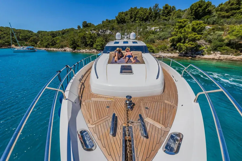 Gitana II Yacht Photos Pics Luxury 2009 Princess V78 yacht cruising in clear blue waters, with sunbather on deck.