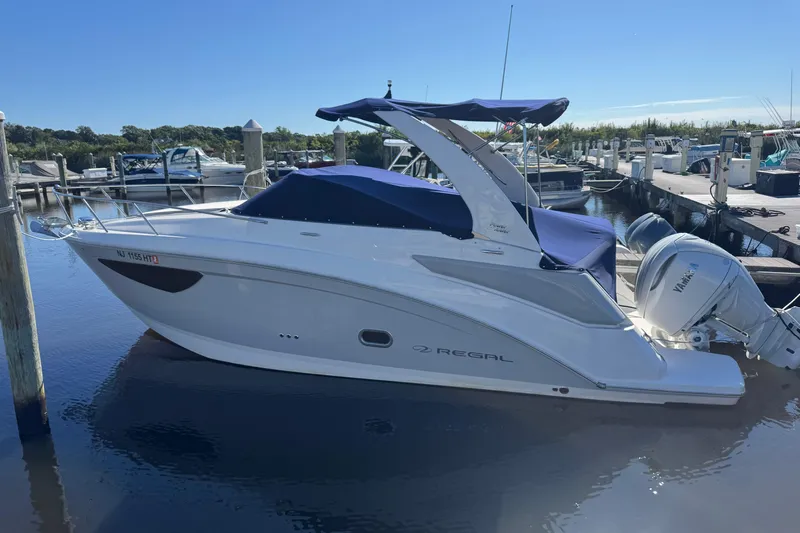  Yacht Photos Pics 2024 Regal 26 XO boat docked at marina, featuring sleek design and Yamaha outboard motor.