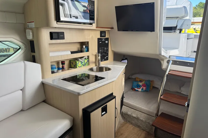  Yacht Photos Pics 2024 Regal 26 XO boat interior with kitchenette, seating, and sleeping area.