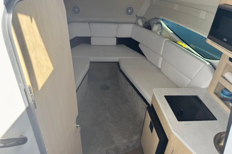  Yacht Photos Pics 2024 Regal 26 XO boat interior with white seating, kitchenette, and modern design.