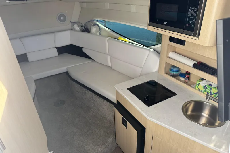  Yacht Photos Pics 2024 Regal 26 XO cabin interior with kitchenette, seating, and modern amenities.