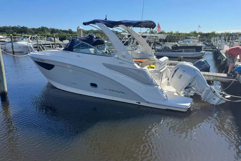  Yacht Photos Pics 2024 Regal 26 XO boat docked at marina, featuring sleek design and Yamaha outboard motor.